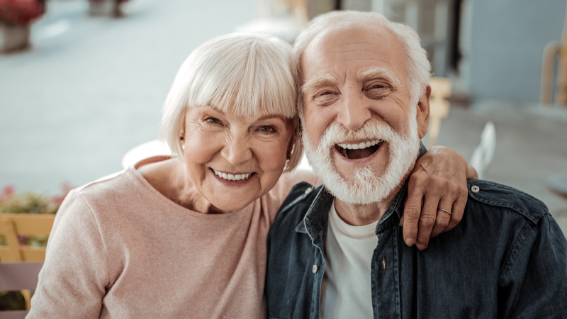 Smiling elderly man and woman lean together