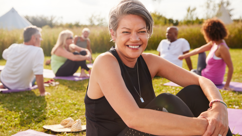woman smiling at yoga retreat in park