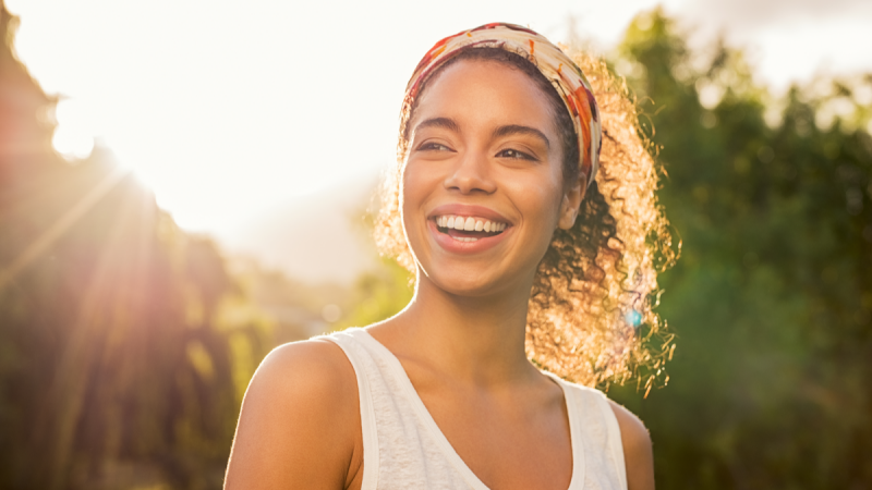 woman smiling and looking away during sunset