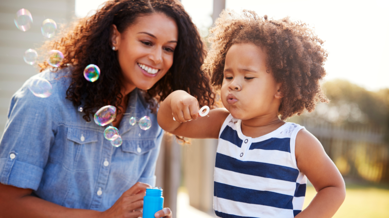 Woman and baby blowing bubbles