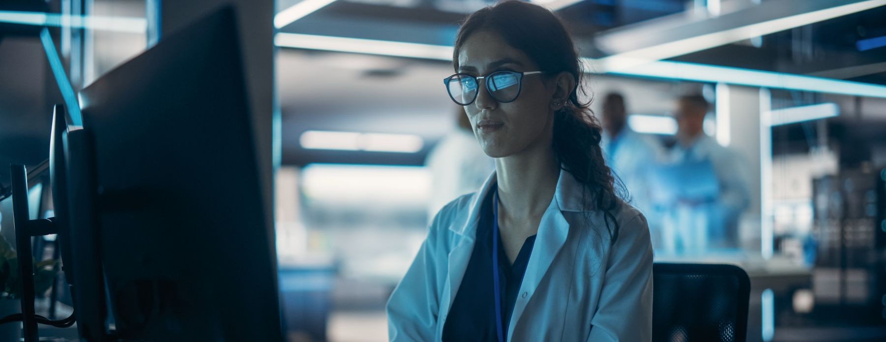 Female Pharmacist with glasses using a computer